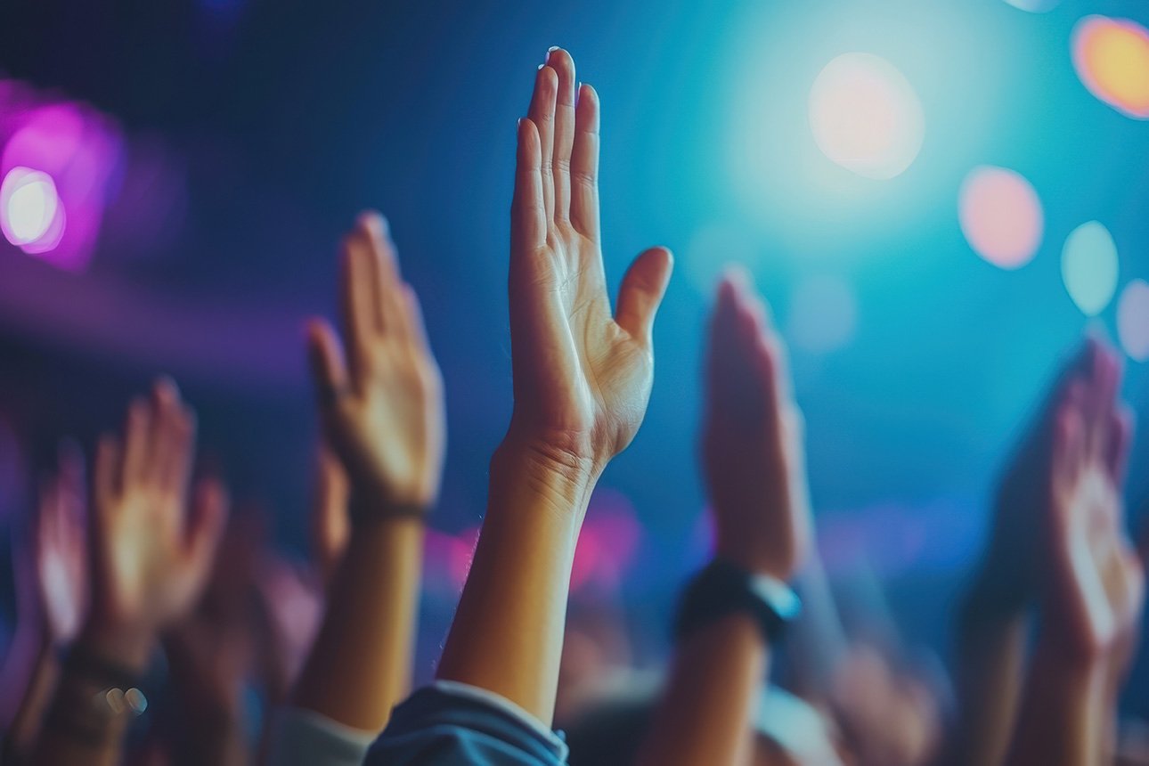 Celebration atmosphere with raised hands in crowd, expressing joy