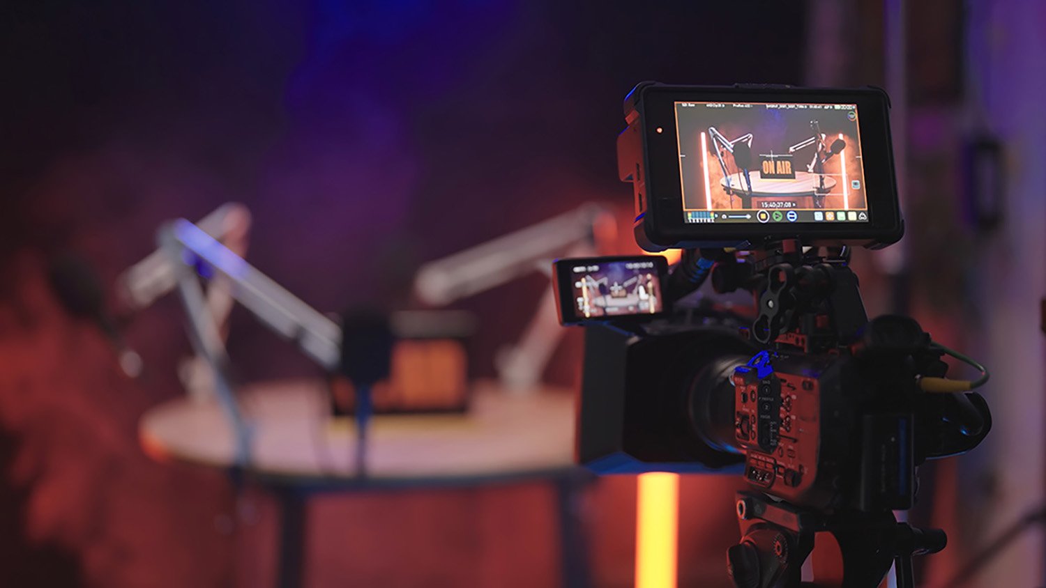Video recording setup featuring cameras and microphones in a podcast studio, highlighting live streaming capabilities for enhanced audience engagement.